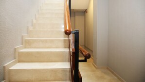 Una escalera con barandillas de madera y escalones color beige.