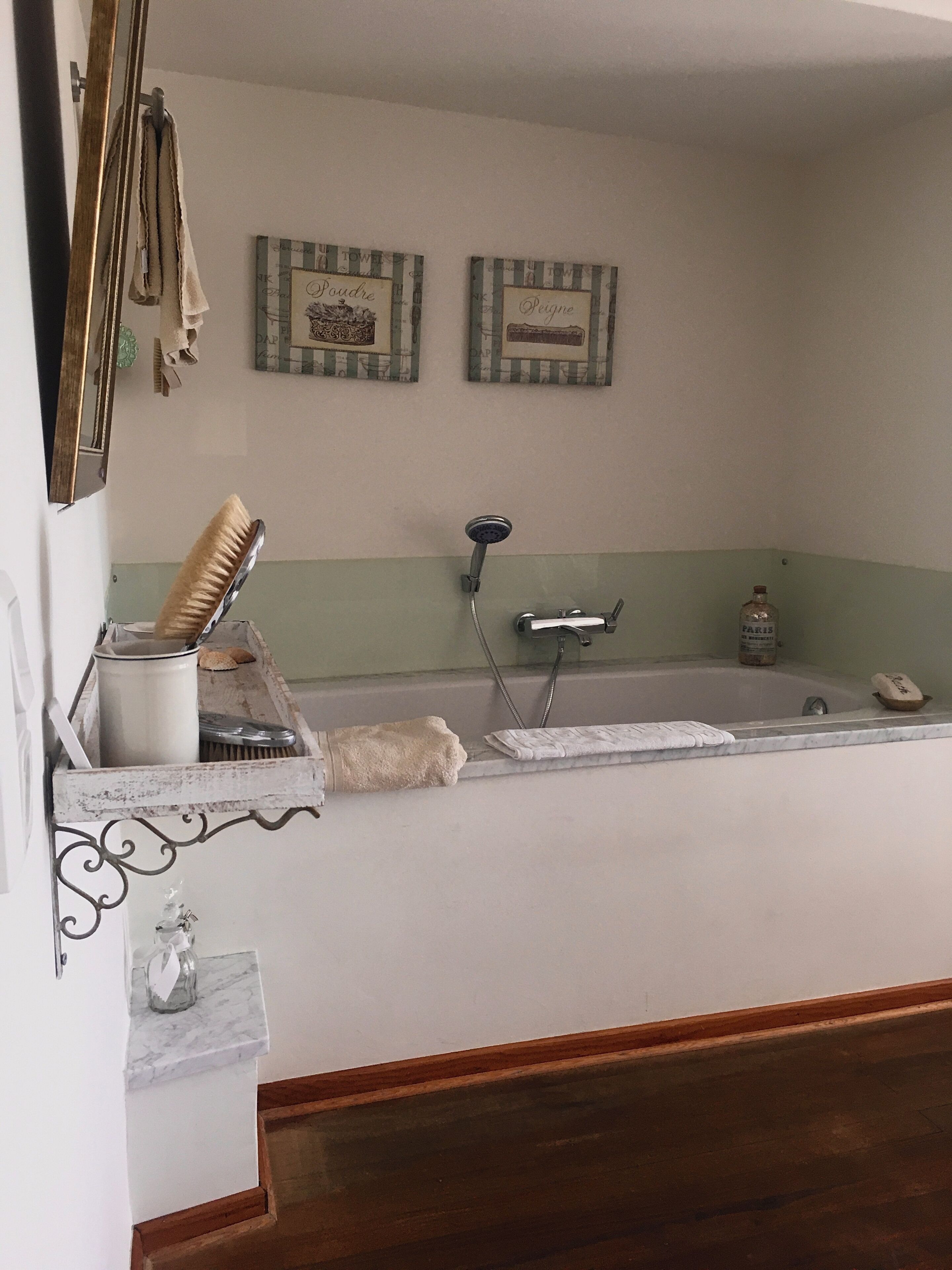 A bathroom with a bathtub, a shower, and a sink. There are towels and a hairbrush on the counter.