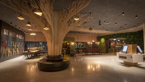 A modern interior with a central tree-like structure, seating areas, and a bar. - Marlin Hotel Stephens Green (Dublin)