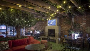 An outdoor seating area with tables and chairs, a fireplace, and string lights. - Marlin Hotel Stephens Green (Dublin)