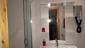 A bathroom with a glass shower enclosure, a white sink with a chrome faucet, and a mirror above the sink. - Pension Zum Bauernstübl (Meerane)