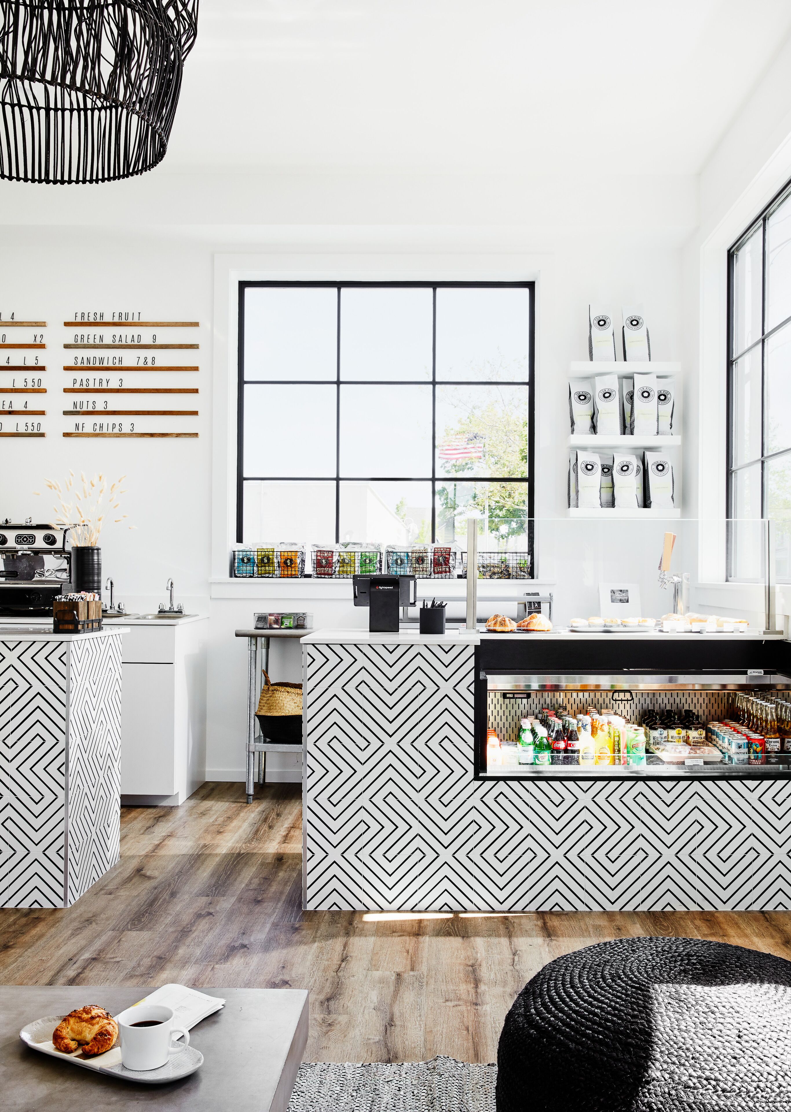 Une cuisine moderne dotée d’un îlot central, d’une grande fenêtre et d’un menu fixé au mur.