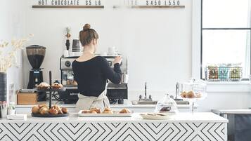 A modern coffee shop interior with a barista preparing drinks.