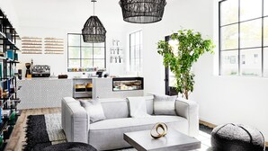Una sala de estar moderna con un sofá gris, alfombra estampada en blanco y negro y una mesita de centro.