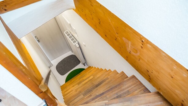 A wooden staircase with a white wall and a door at the top. - Tripcologne Apartments since 2013 (Cologne)