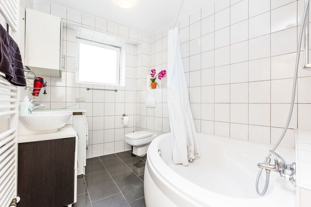 Ein modernes Badezimmer mit Badewanne, Toilette und Waschbecken.