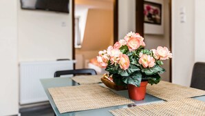 A dining table with a potted plant and woven placemats. - Tripcologne Apartments since 2013 (Cologne)
