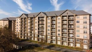 Un edificio residencial de varios pisos con fachada uniforme, varios balcones y cielo despejado.