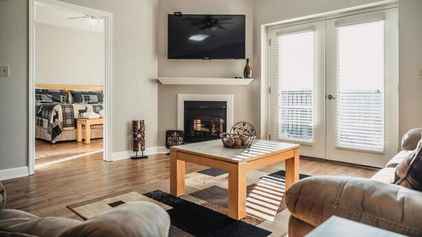 Una sala de estar con chimenea, televisión y comedor.