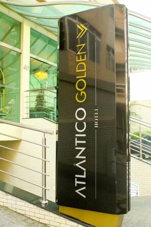 A black and yellow sign for the Atlantic Golden Hotel. - Atlântico Golden Apart Hotel (Santos)