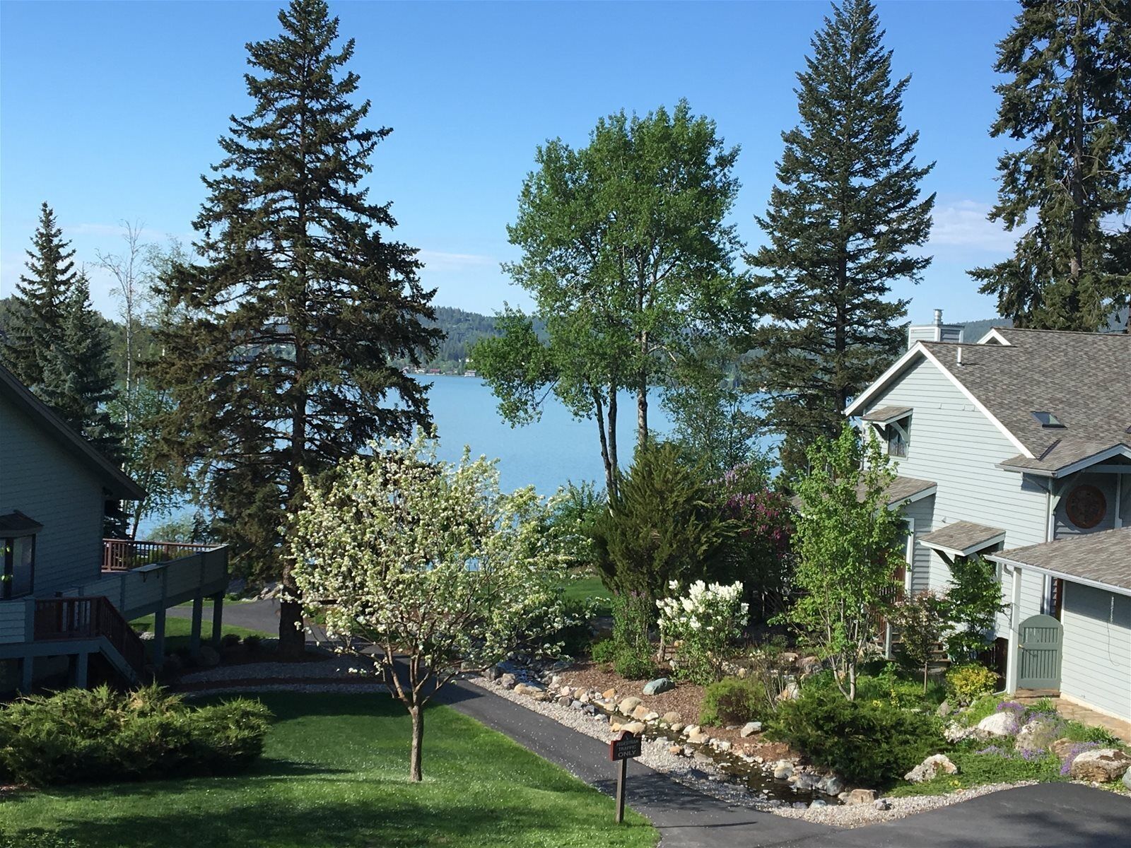 A residential area with houses, a lake, and a clear sky.