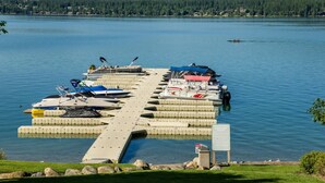 A private dock with several boats moored, a clear view of the lake, and a sign indicating the dock is private. - Mountain Harbor #137 3 Bedroom Condo (Whitefish)