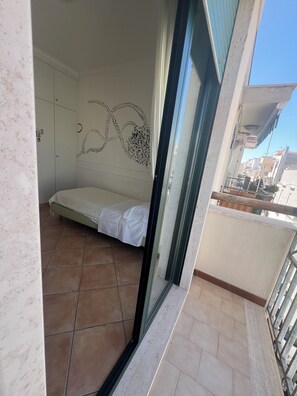 A room with a bed, a wardrobe, and a decorative wall design.