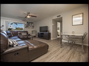 Relax in this stylish living room with a comfortable sofa, flat-screen TV, and dining area.
