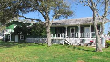 A two-story house with a green exterior and a porch.