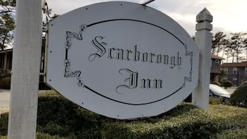 A sign for the Seckahborough Inn, featuring a simple, elegant design with decorative floral elements.