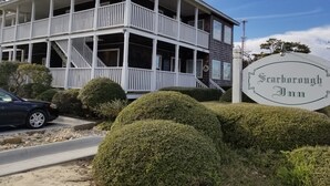 A two-story building with a porch and a sign reading "Scarborough Inn".