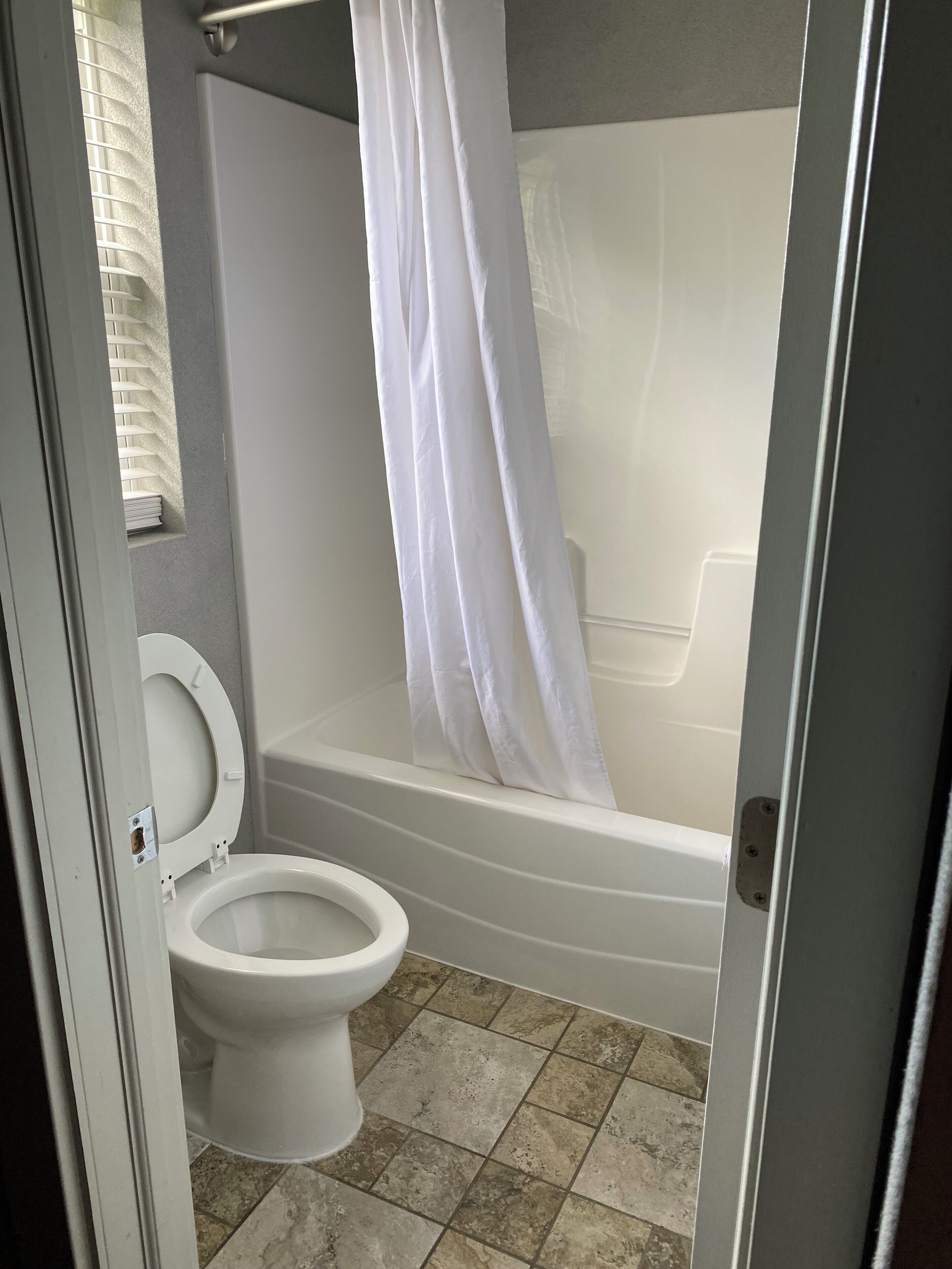 Ein Badezimmer mit Toilette, einer Badewanne und einer Duschvorhang.