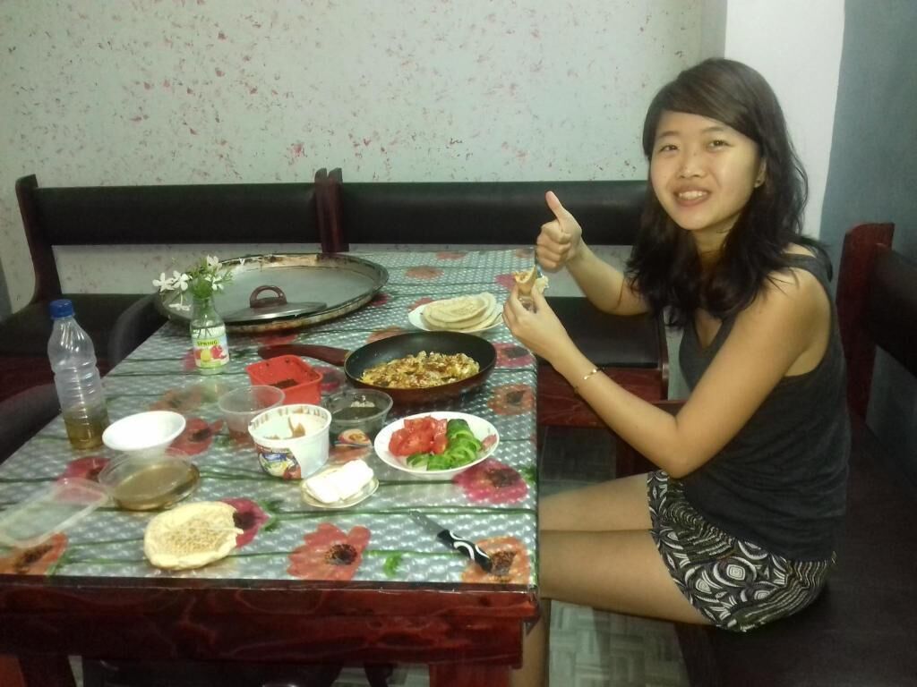A dining table with various dishes and a bottle.