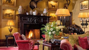 A traditional room with a fireplace, framed artwork, and classic furniture. - Dromoland Castle (Newmarket on Fergus)