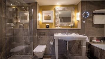 A modern bathroom with a glass-enclosed shower, a toilet, a sink with a vanity, and a large mirror.