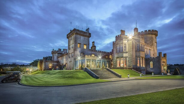 A castle-like building with a grand entrance, multiple towers, and a well-maintained lawn. - Dromoland Castle (Newmarket on Fergus)