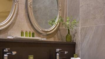 A bathroom with two mirrors, a sink, and a towel rack.