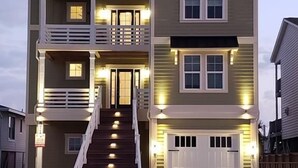 Un immeuble résidentiel à plusieurs étages, doté d’un escalier central, de nombreuses fenêtres et d’un garage.