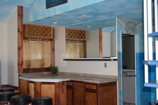 A bathroom with wooden cabinetry, a large mirror, and a sink.