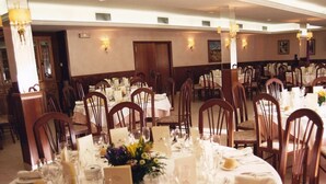A banquet hall with round tables set for a formal event, featuring white tablecloths, floral centerpieces, and neatly arranged cutlery. - Hotel La Seu (La Seu d'Urgell)