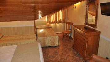 Un dormitorio con dos camas, un aparador de madera, una silla y un televisor.