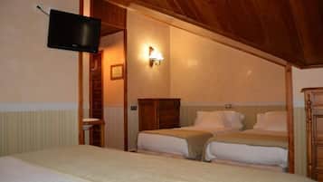 Un dormitorio con dos camas, una televisión instalada en la pared y un armario de madera.