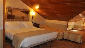 A bedroom with a large bed, two smaller beds, a mirror, and a wooden ceiling.