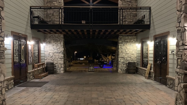 Eine geräumige Lobby mit Steinboden, Holzbalken und einem Balkon mit Metallgeländern.