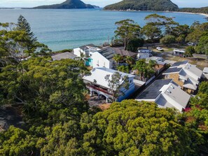A residential area with houses, trees, and a body of water in the background. - Shoal Bay Av 1 Ground floor (Shoal Bay)