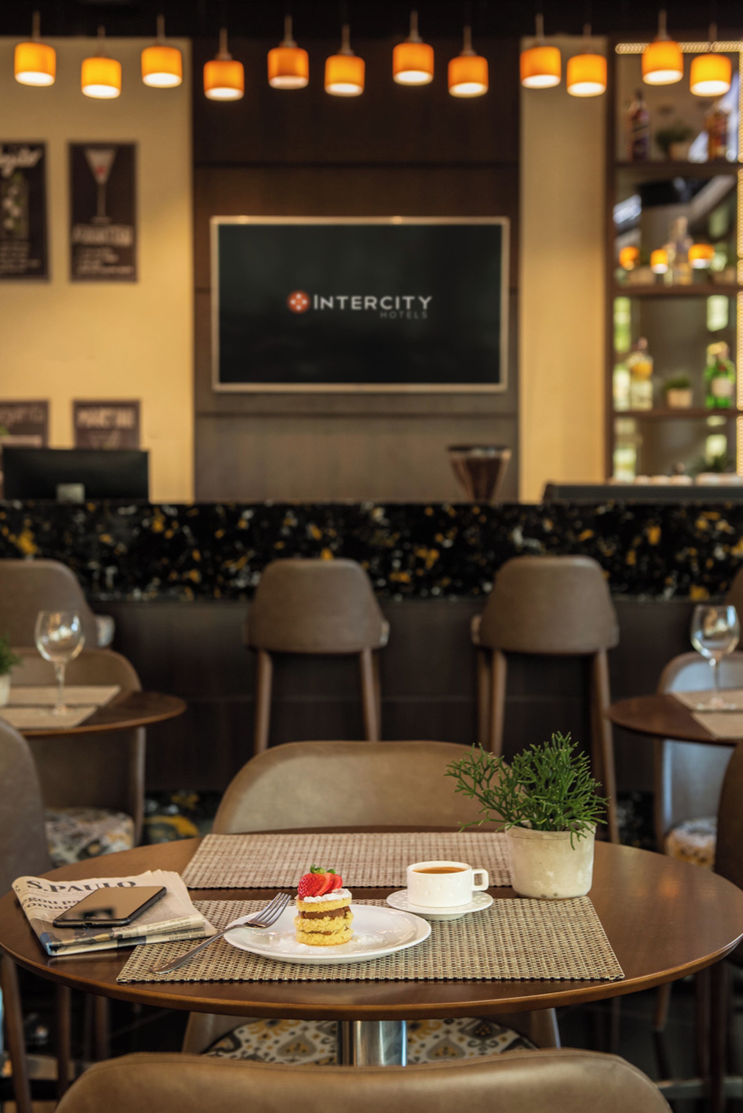 A restaurant setting with tables, chairs, and a dessert on a plate.