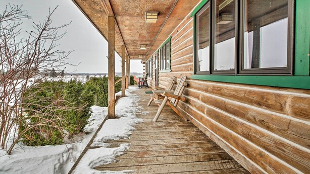 A wooden cabin with a covered porch and large windows.