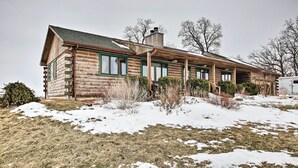 A log cabin with a covered porch and a chimney.