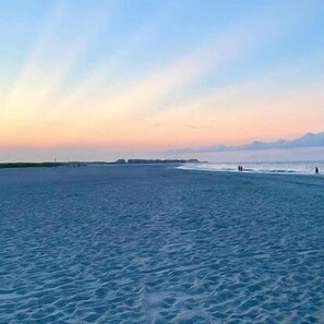 A beach with calm water and a clear sky.