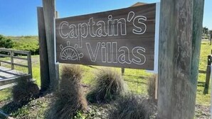 Un cartello di legno con la scritta 'Captain's Villas' e l'icona di una barca a vela.