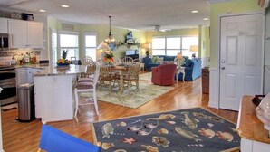 A spacious living area with a dining table, chairs, and a red sofa. - Turtle Cove is a spacious 4-bed home in Holden Beach, perfect for 9 guests. (Holden Beach)