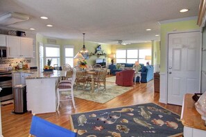 A spacious living area with a dining table, chairs, and a red sofa.