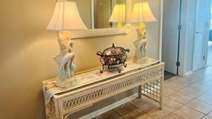 Un tavolo consolle con due lampade, uno specchio e oggetti decorativi.