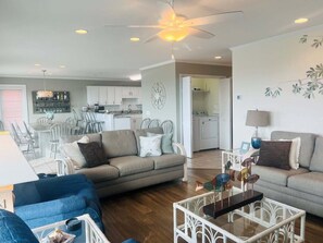 A living room with a sofa, a coffee table, and a dining area with chairs and a table.