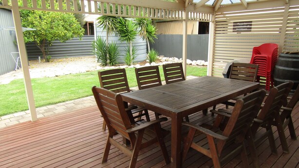 A covered patio with a wooden table and chairs, a grill, and a sign indicating a private property. - The Catch  ~ short walk to beach! Dog Friendly  - Off Peak Special! (Stansbury)
