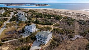 A coastal property with multiple houses, a beach, and a clear view of the ocean. - Cypress Hall: Stunning 6-Bedroom, Oceanfront Retreat in Holden Beach! (Holden Beach)