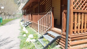 Una cabaña de madera con un porche, escalones y vistas a la montaña.