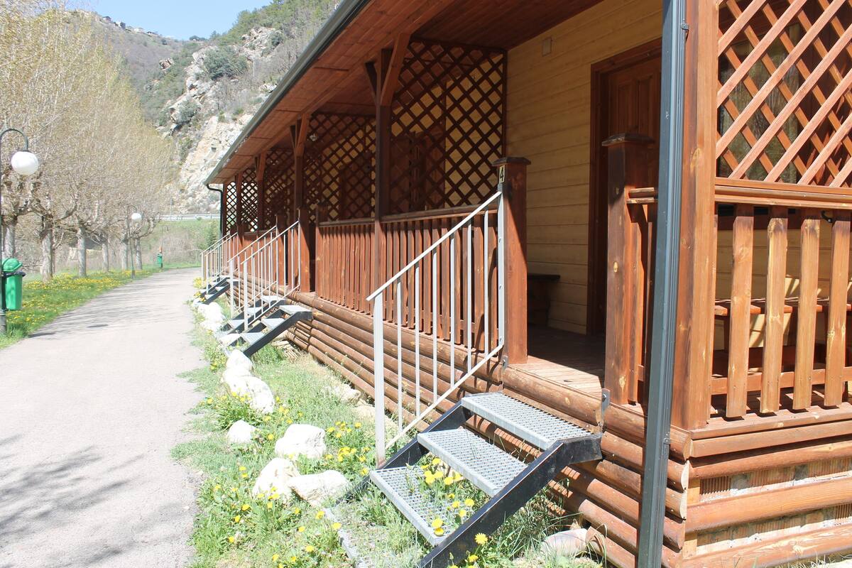 Une cabane en bois avec une véranda, des marches et une vue sur une montagne.