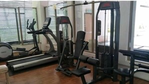 A gym with cardio machines, weightlifting equipment, and a bench. - Triple B's Staycation - Simple and Comfy (Petaling Jaya)