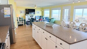 A kitchen with white cabinets, a granite countertop, and a built-in stove. - Experience oceanfront bliss at Summer Sandcastle, a spacious 5BR home in Holden Beach! (Holden Beach)